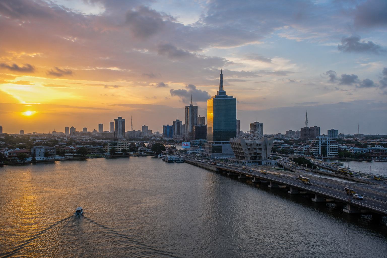 Sunrise over the Lagos lagoon — a single boat on flat water, bridge traffic already moving, towers catching first light.