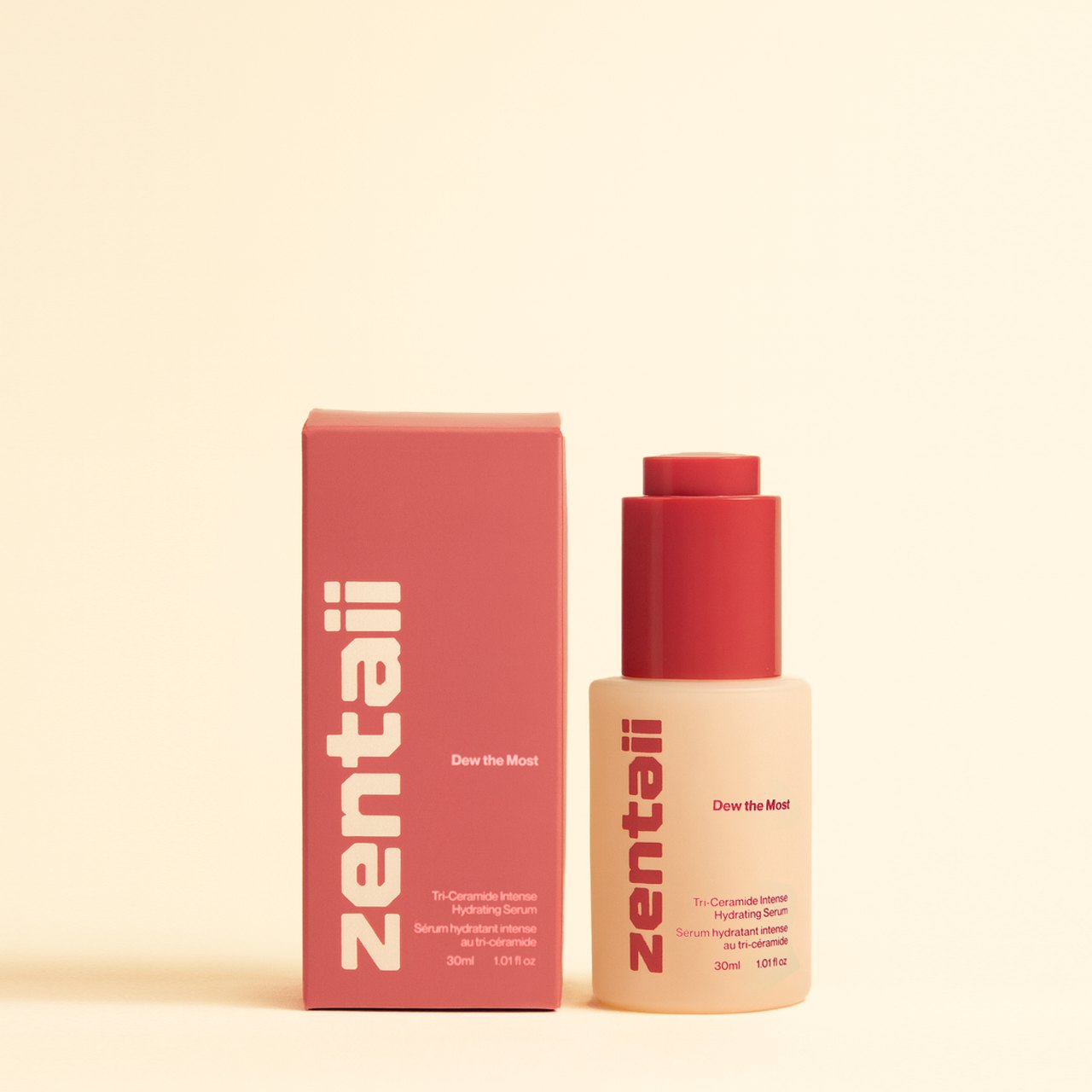 The deep red serum carton standing beside its frosted glass bottle on a cream ground.