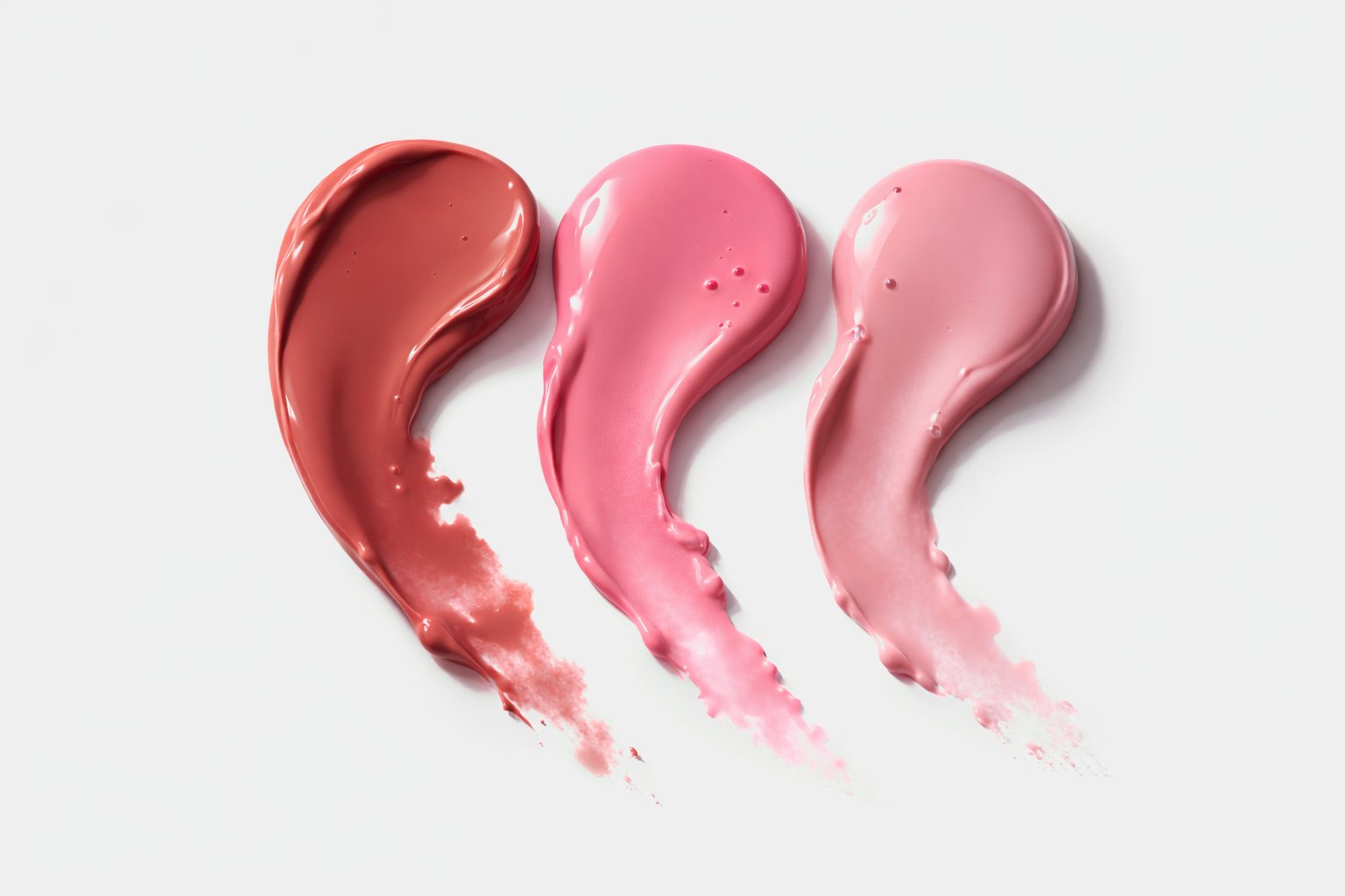 Three lip shades swatched side by side on white — a berry, a mid pink and a soft rose.